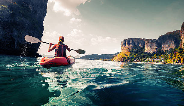 Lady paddling the kayak in the calm tropical bay