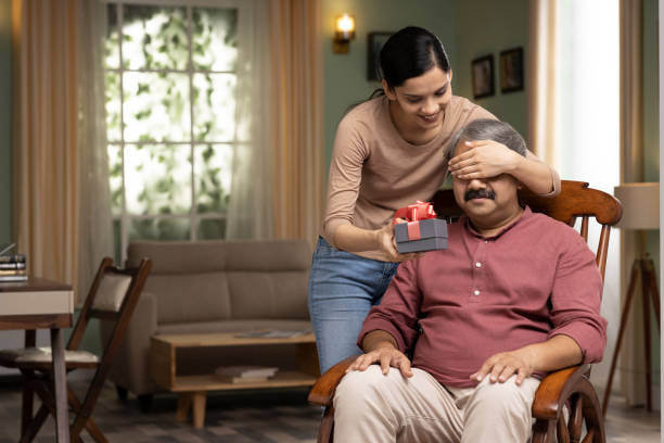 girl celebrating father’s day, greeting excited dad with box