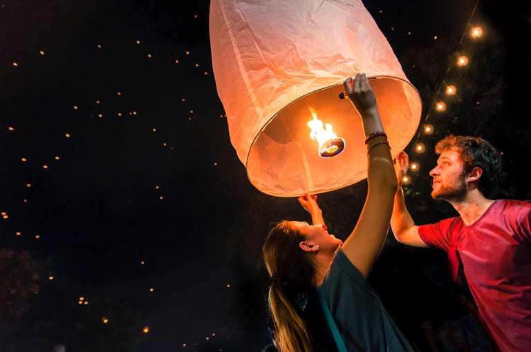 man-and-woman-holding-paper-lantern-during-yi-peng-festival--thailand